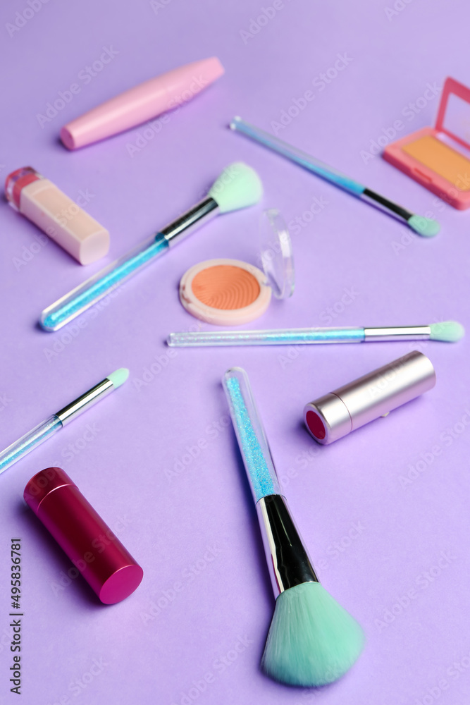 Composition with makeup brushes and cosmetic products on purple background Composition with makeup brushes and cosmetic products on purple background