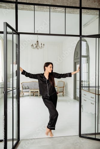 Young  woman in black silk .pajamas possing at home