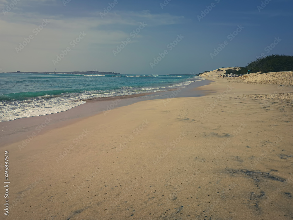 Exotic beach view in Africa. Romantic seascape, sandy surface, turquoise Atlantic Ocean water and vacation mood. Selective focus on the details, blurred background.