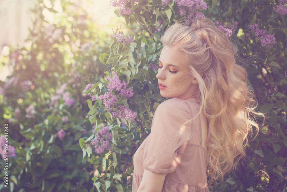 Gentle young woman on lilac flowers background Gentle young woman on lilac flowers background