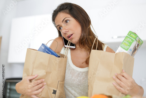 smiling woman with mobile phone holding shopping bags photo