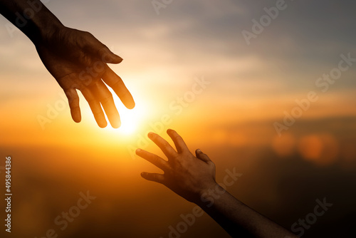 Silhouette of reaching, giving a helping hand, hope and support each other over blur sunset sky background. concept of international day of peace and develop a friendship.