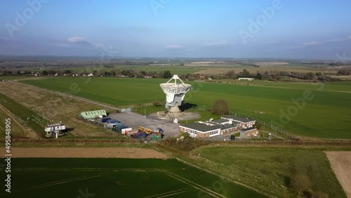 Drone shot flying towards a large satellite dish in rural countryside photo