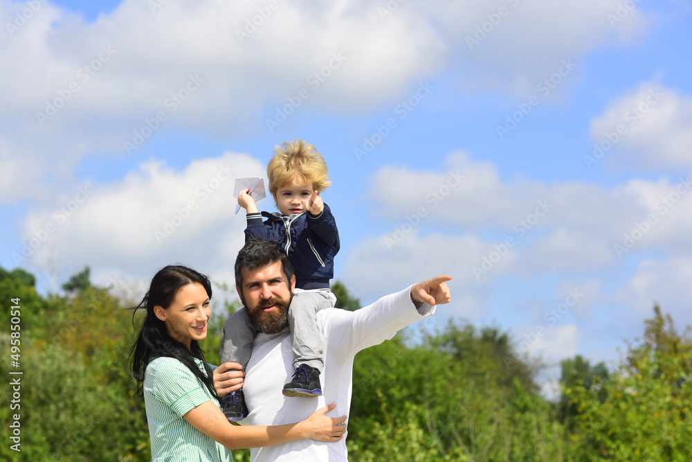 Happy family mother father and child son laughing and havig fun with toy paper plane. Family Weekend. Portrair of cheerful parents and their little child. Children day. Happy family mother father and child son laughing and havig fun with toy paper plane. Family Weekend. Portrair of cheerful parents and their little child. Children day.