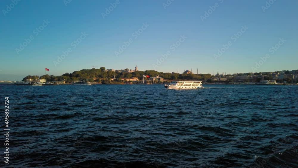 View of Ist Bosphorus with Hagia Sophia (Ayasofya Camii) in the background in Istanbul, Turkey. Tourist boat passing by at sunset. View of Ist Bosphorus with Hagia Sophia (Ayasofya Camii) in the background in Istanbul, Turkey. Tourist boat passing by at sunset.