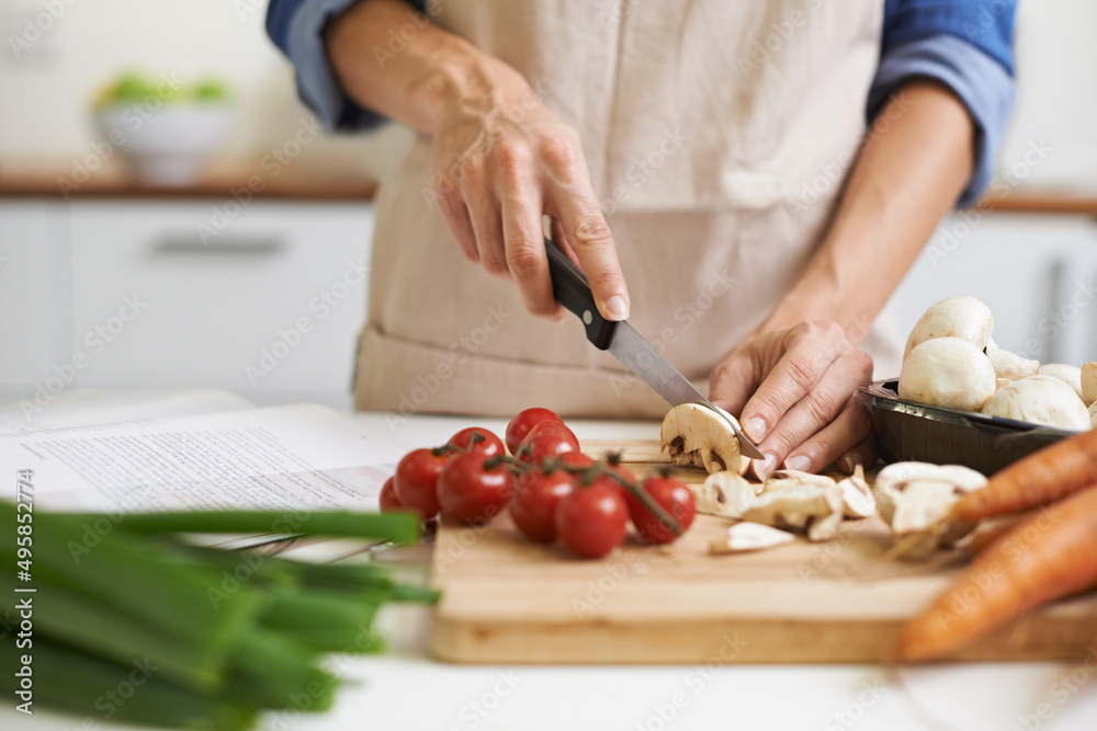 The beginnings of something delicious. A young woman chopping vegetables. The beginnings of something delicious. A young woman chopping vegetables.