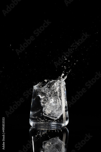 glass with water ice and splashes on a black background © Александр Иванов