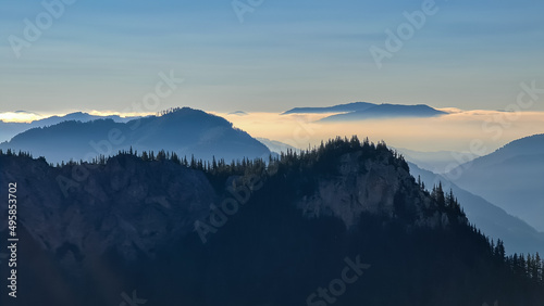 Fototapeta Naklejka Na Ścianę i Meble -  A panoramic view on the mountain peaks of the Hochschwab Region in Upper Styria, Austria. Cloudless weather on a sunny summer day in the Alps. Blue misty valley and soft hills. Concept freedom