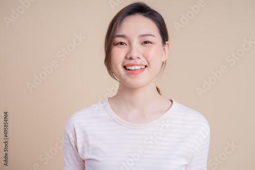 Portrait of young Asian girl posing on background