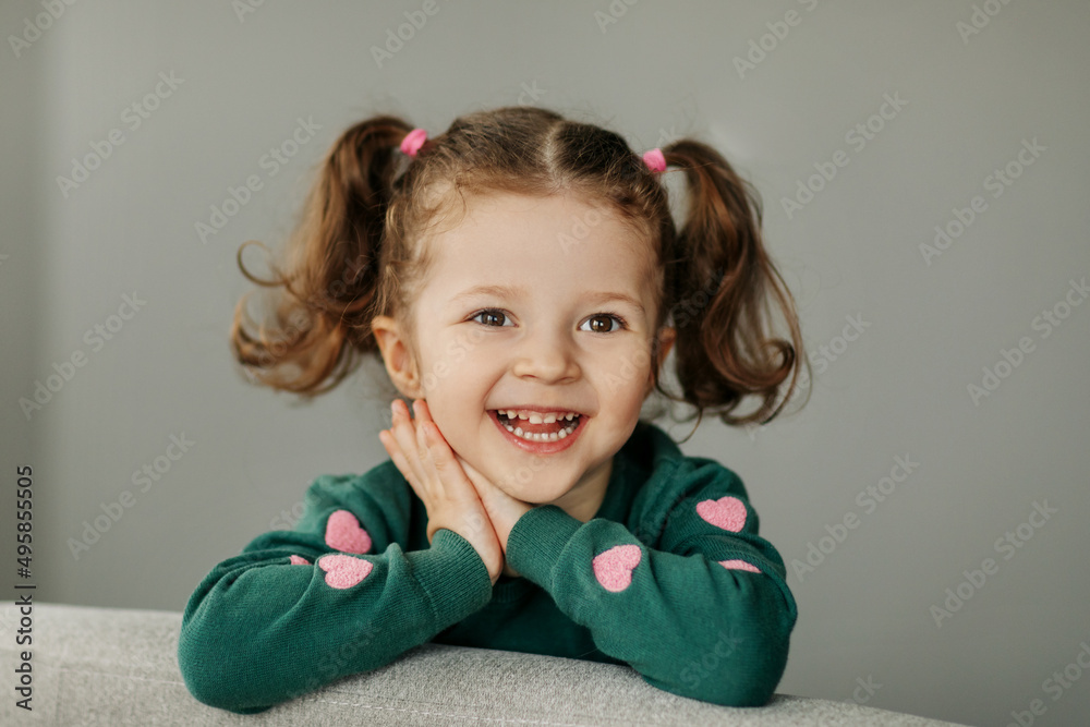 Portrait of a charming little girl with two ponytails, joyful and smiling Portrait of a charming little girl with two ponytails, joyful and smiling