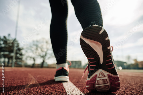 Sport runner girl training. Run woman workout exercise. Runner feet running on road closeup on shoe. Fitness, sport, lifestyle concept.
