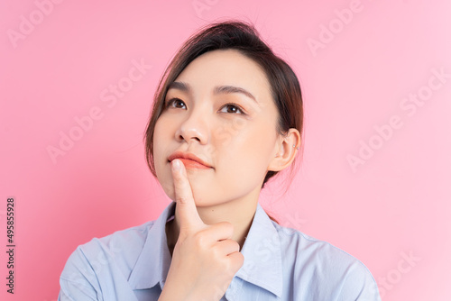 Portrait of young Asian girl posing on pink background