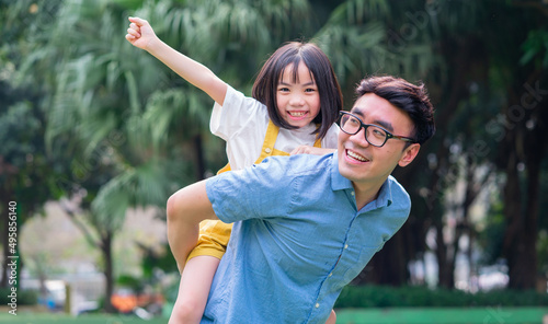 Image of Asian father and daughter playing together at park