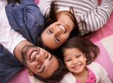 The strongest family bonds. High angle portrait of a happy young family lying on their backs at home.