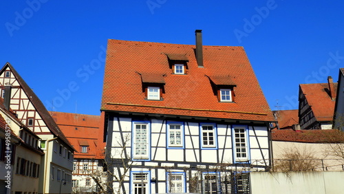 schmuckes altes Fachwerkhaus mit rotem Dach unter blauem  Himmel im Zentrum von Nagold gelegen photo