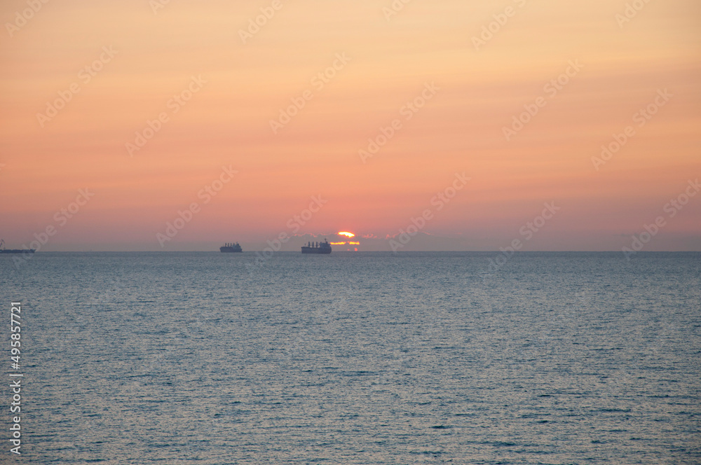 sunset sky and sea with ship on horizon, summer