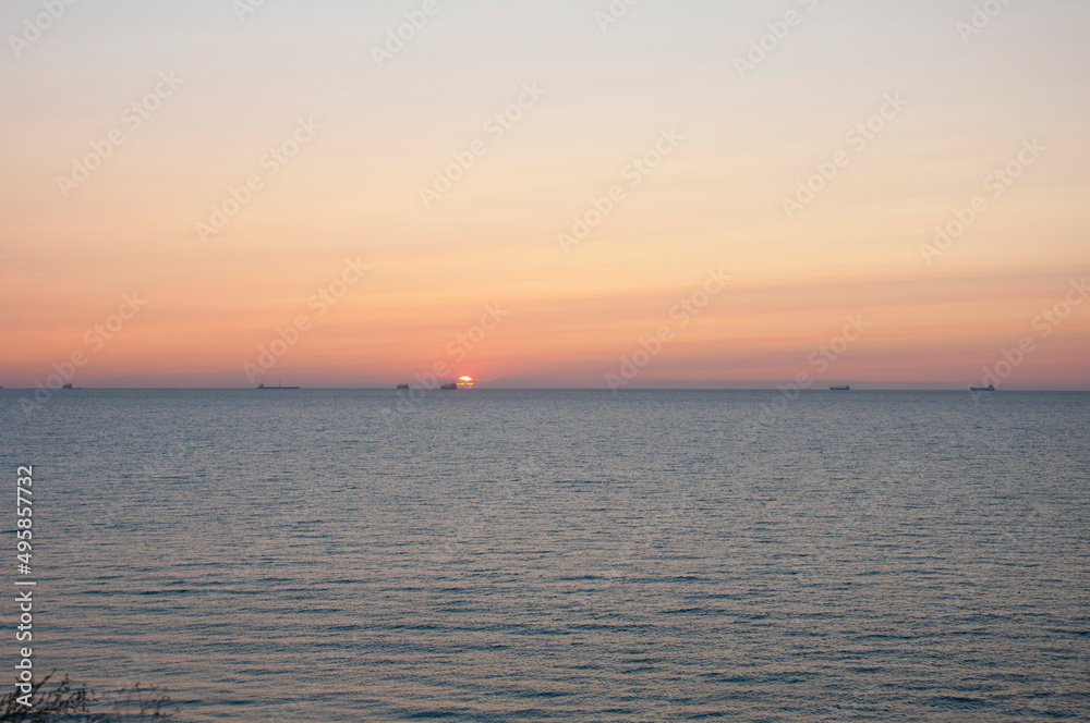 sunset sky and ocean with ship on horizon, summer sunset sky and ocean with ship on horizon, summer
