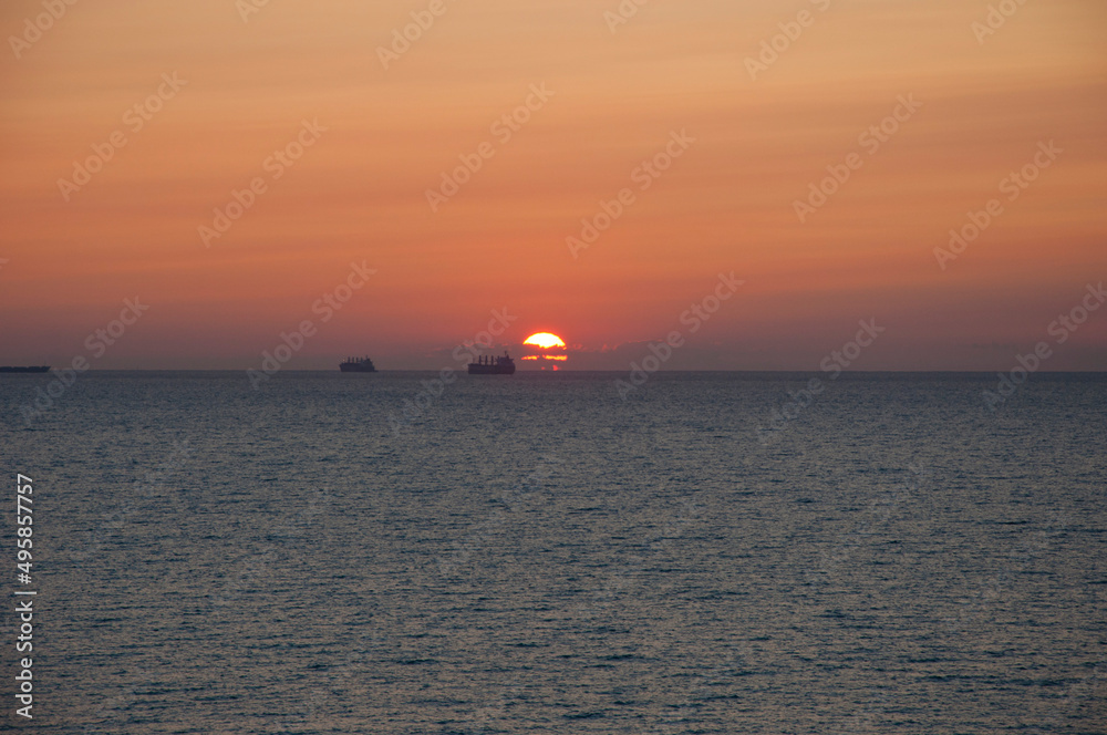 sunset sky and sea with ship on horizon, summer holiday