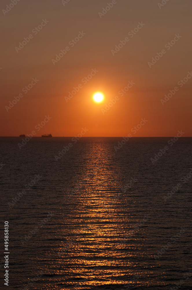 sunrise sun and seascape with ship on horizon, summer