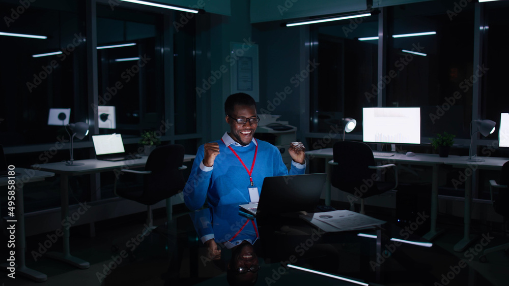 African-American entrepreneur work on laptop and raise fists celebrating success African-American entrepreneur work on laptop and raise fists celebrating success