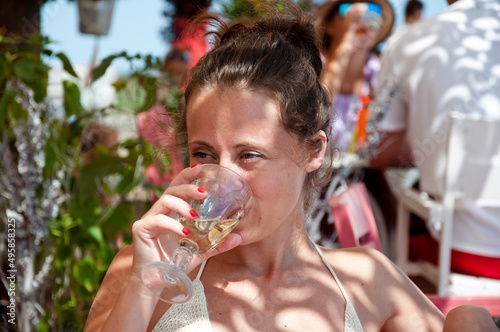 young woman drink wine in summer restaurant on vacation resort photo