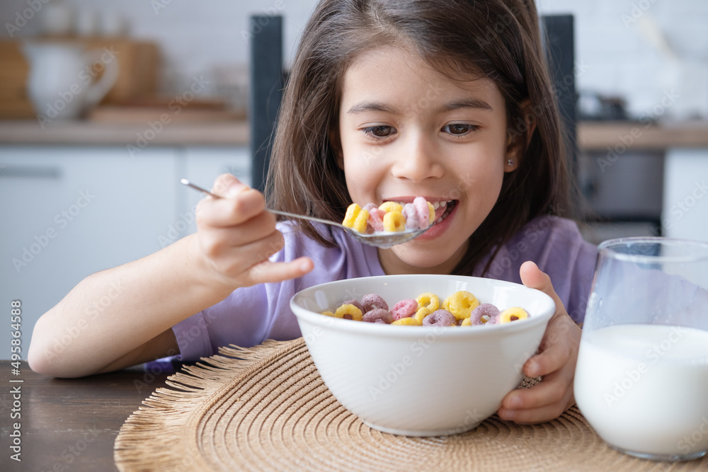 Happy arab child girl having breakfast colorful cereal with milk at home on the morning Happy arab child girl having breakfast colorful cereal with milk at home on the morning