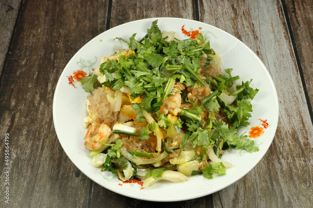 Traditional fried and stirred vermicelli or glass noodle with Chinese celery serving on the plate. Famous street food menu in Asia restaurant. Traditional fried and stirred vermicelli or glass noodle with Chinese celery serving on the plate. Famous street food menu in Asia restaurant.