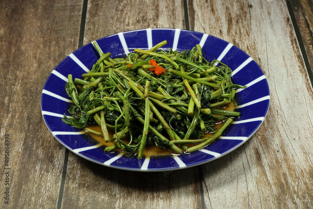 Traditional fried and stirred water mimosa with chilly and fish sauce serving on the plate. Famous spicy vegetarian menu in Asia restaurant. Traditional fried and stirred water mimosa with chilly and fish sauce serving on the plate. Famous spicy vegetarian menu in Asia restaurant.