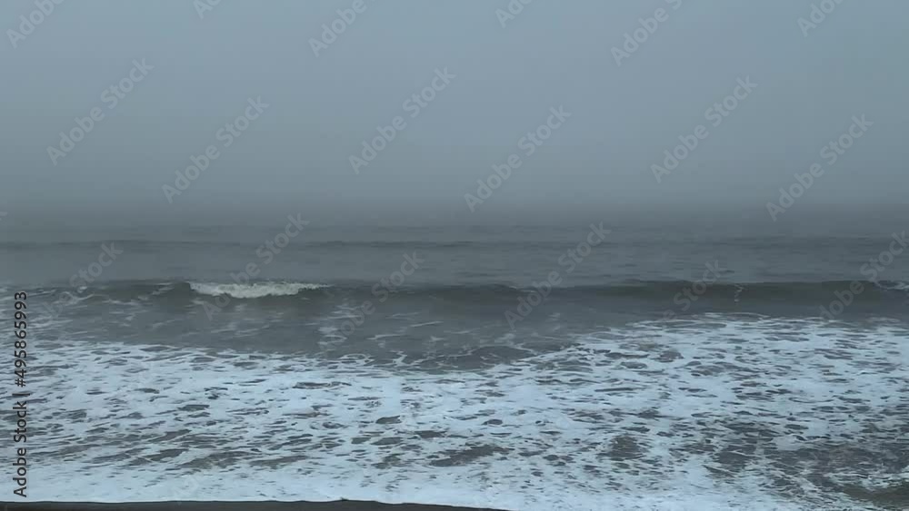 Misty grey sky above gloomy ocean waves at the seaside beach. Misty grey sky above gloomy ocean waves at the seaside beach.