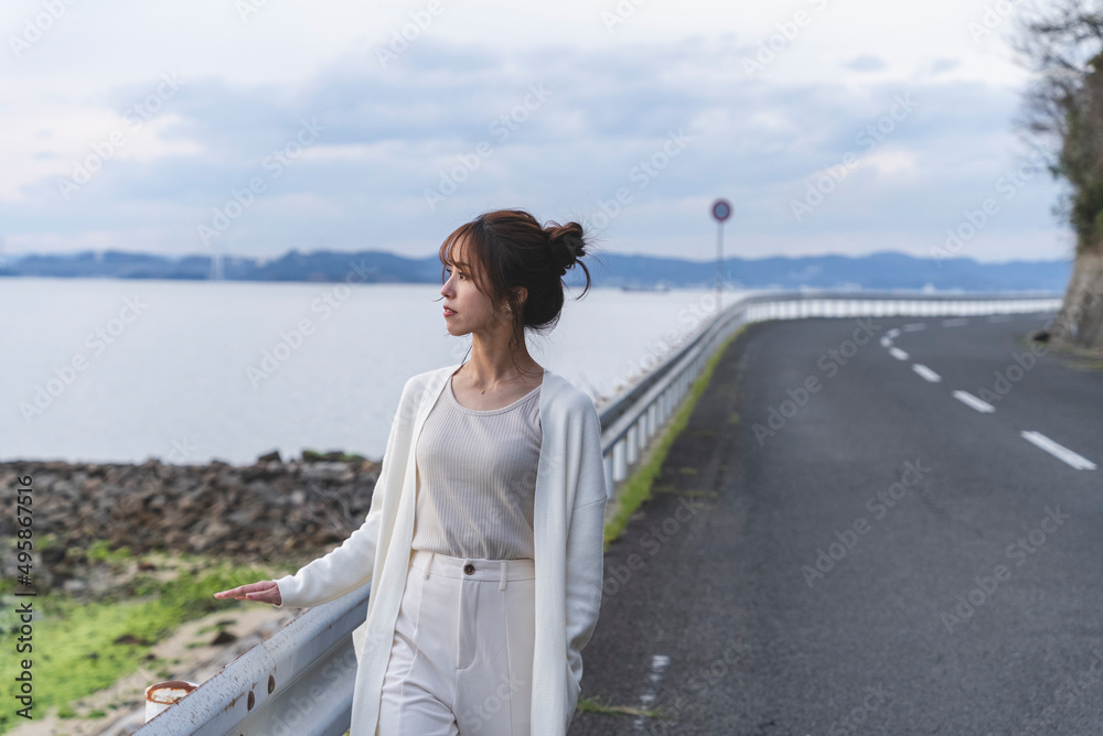夕暮れの海岸線を歩く女性 夕暮れの海岸線を歩く女性