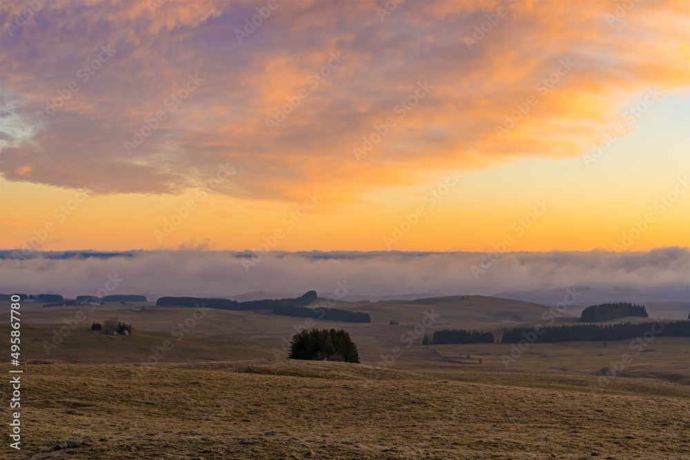 Colorful Sunrise Over Lowlands With Mist Moving Fast and Cloudy Orange Sky