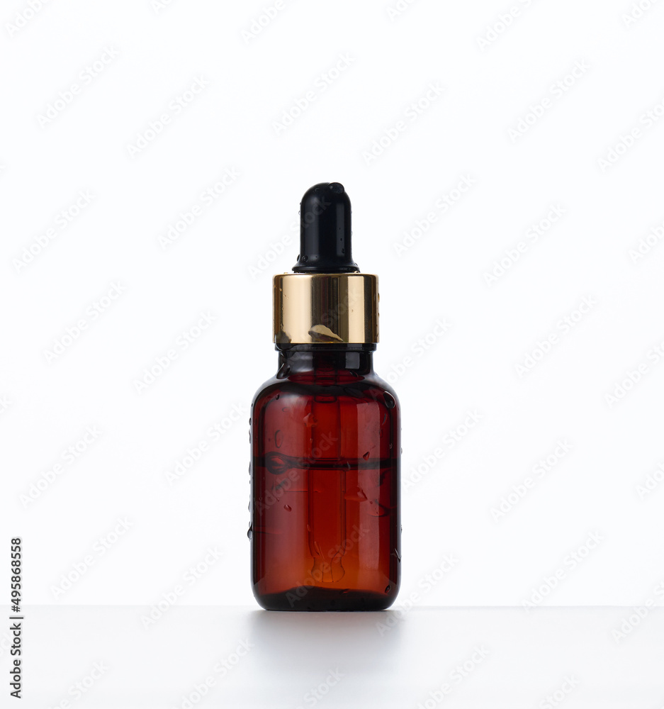 brown glass bottle with a pipette on a white background. Container for cosmetics, oils, serums. Advertising and product promotion brown glass bottle with a pipette on a white background. Container for cosmetics, oils, serums. Advertising and product promotion
