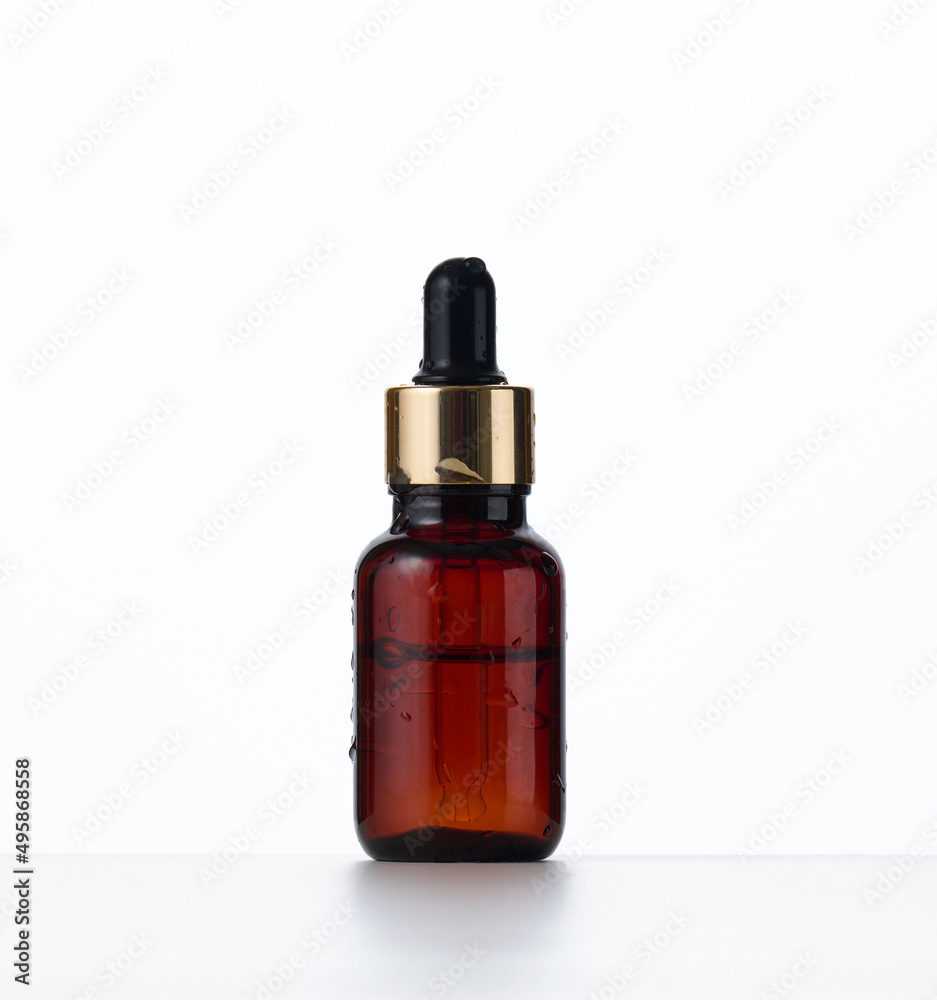 brown glass bottle with a pipette on a white background. Container for cosmetics, oils, serums. Advertising and product promotion