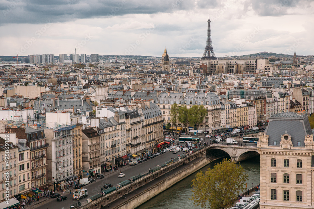 View from the Notre Dame de Paris to Parisian residential buildings and Eiffel Tower. Seine river, cloudy sky. Travelling to Paris. Wanderlust. 