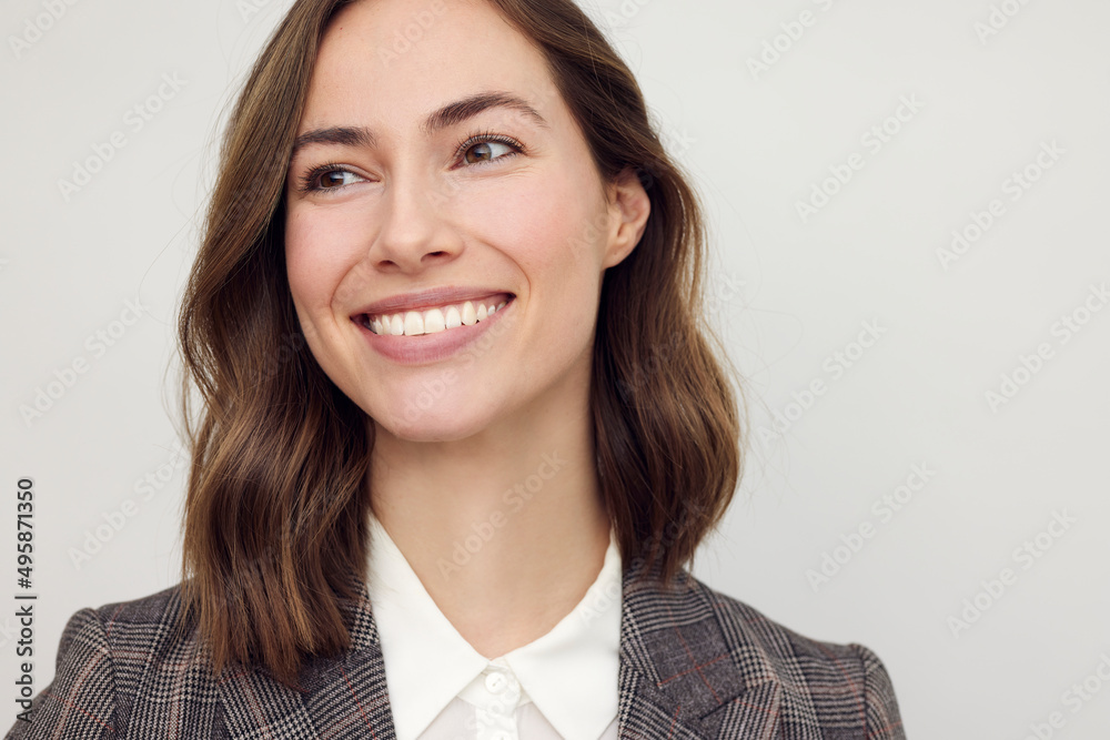 Close-up portrait of beautiful young businesswoman looking happy and confident to the left. Big smile on her face, looking beautiful and cheerful standing isolated on white background. Close-up portrait of beautiful young businesswoman looking happy and confident to the left. Big smile on her face, looking beautiful and cheerful standing isolated on white background.