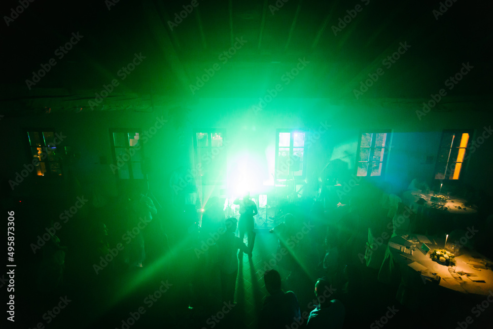 Silhouette image of people dance at wedding party by night. New year night party and nightlife concept.