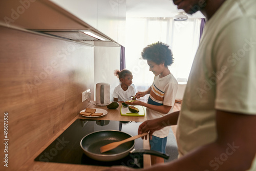 Young family cooking breakfast at home kitchen