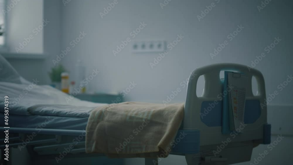 Closeup empty hospital bed with medical records attached in intensive care unit.