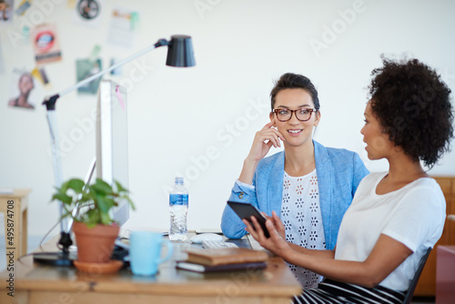 Shot of an attractive young woman sitting at her workstation in the office. The commercial designs displayed in this image represent a simulation of a real product and have been changed or altered