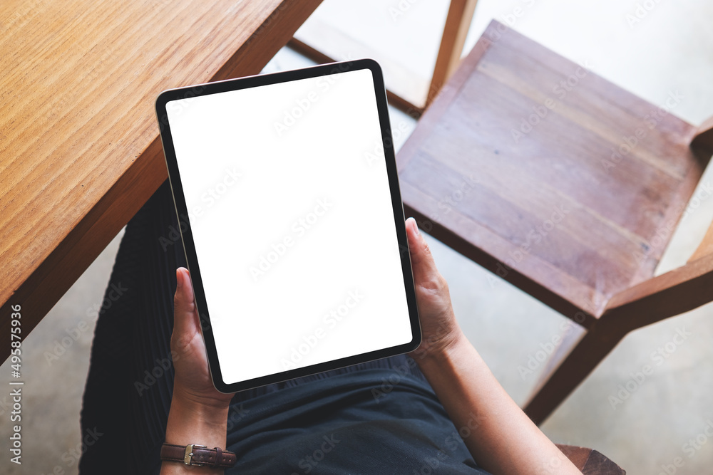 Top view mockup image of a woman holding digital tablet with blank white desktop screen in cafe Top view mockup image of a woman holding digital tablet with blank white desktop screen in cafe