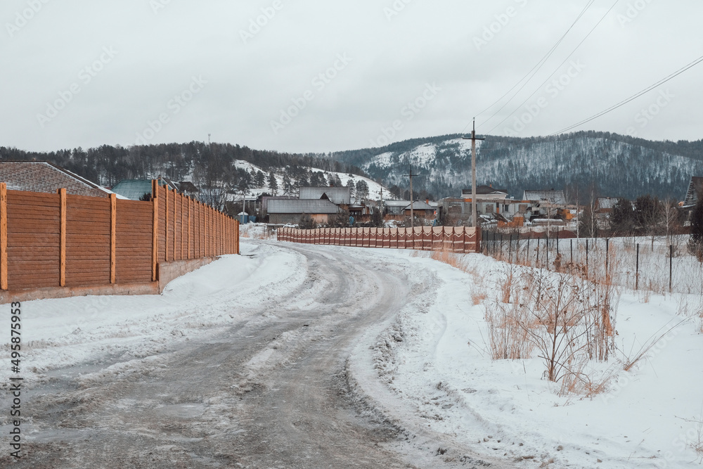 Obraz premium March in the village of Mansky, the snow began to melt, wooden cottages