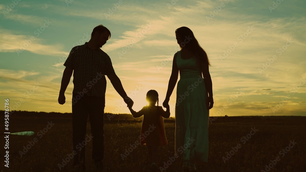 silhouette affectionate parents with child sunset. happy african family sunset park. mother father hold kid hands walking against sky. cheerful multicultural family. child kid nature. travel outside.