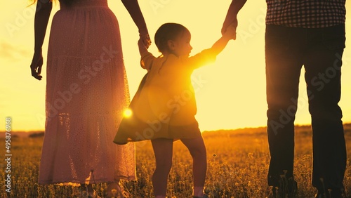 silhouette cheerfully playing girl sunset. child with parents cheerfully jumps runs sun. happy family life together. summer time family vacation. child kid with mother father walk hand park. outside. #495876968