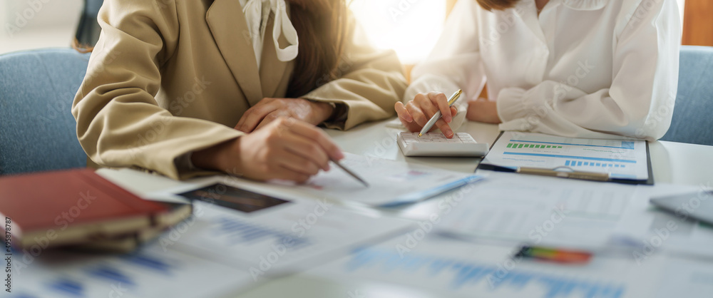 Φωτογραφία Crop image of business partnership coworkers using a calculator analysis graph company financial budget report and cost work progress and planning on workplace