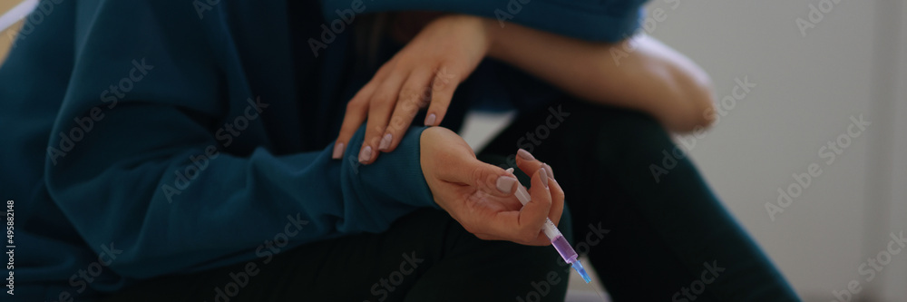 Drug addict person stoned after narcotic injection sitting on floor Drug addict person stoned after narcotic injection sitting on floor