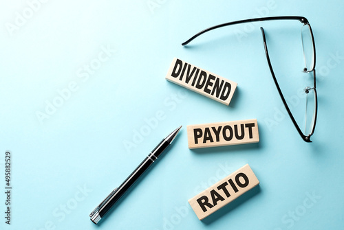 Text DIVIDEND PAYOUT RATIO concept on wooden block on the blue background