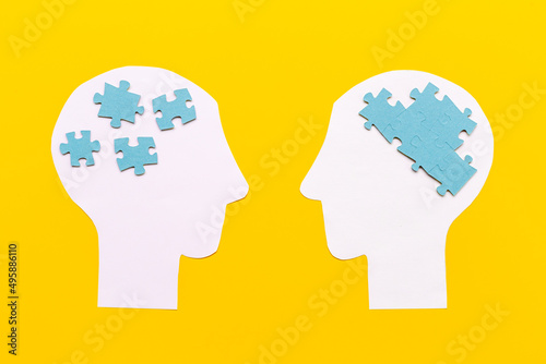Communication. Chaos and peace in brain - two paper human heads with puzzles