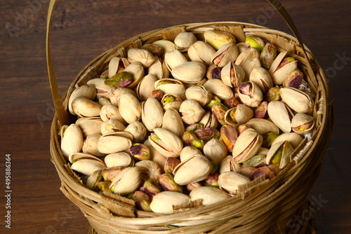 Fresh almonds in the wooden bowl, Organic almonds, almonds border white background, Almond nuts on a dark wooden background. Healthy snacks. Top view. Free space for text. photo