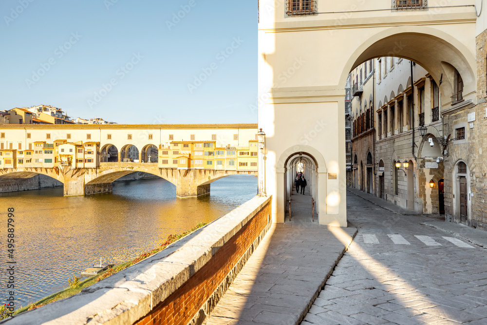 Morning view on famous Old bridge called Ponte Vecchio and arcade on Arno river in Florence, Italy. Concept of traveling Italy and visiting italian landmarks
