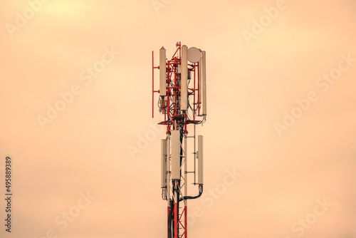 Mobile phone and internet cell tower over against sky. 5G wireless radiation antennas.